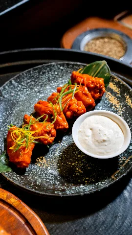 Buffalo wings on a plate with a creamy dipping sauce
