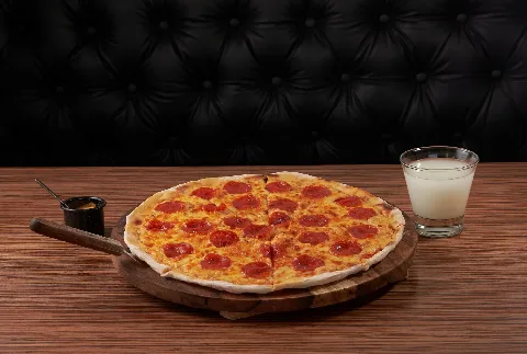 Whole pepperoni pizza on a wooden board