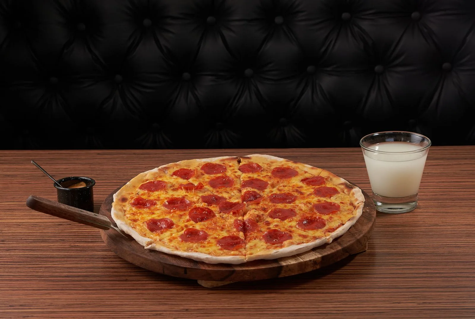 Whole pepperoni pizza on a wooden board